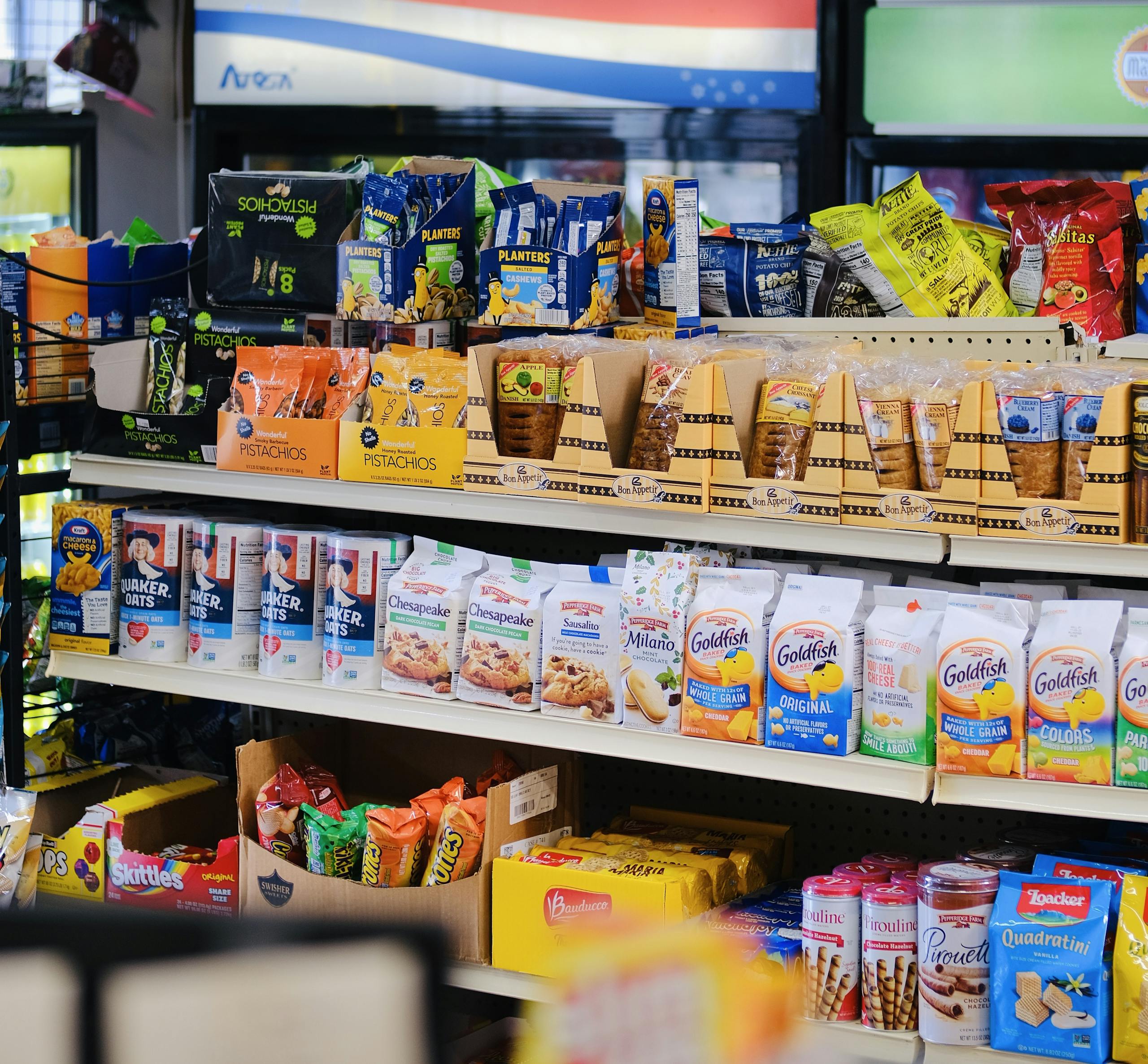 A variety of packaged snacks and sweets displayed on store shelves.