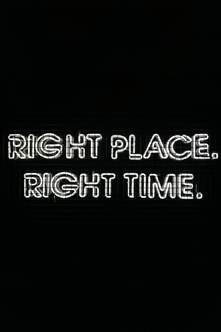 Glowing neon text on a black background saying 'Right Place. Right Time.' for motivation and inspiration.