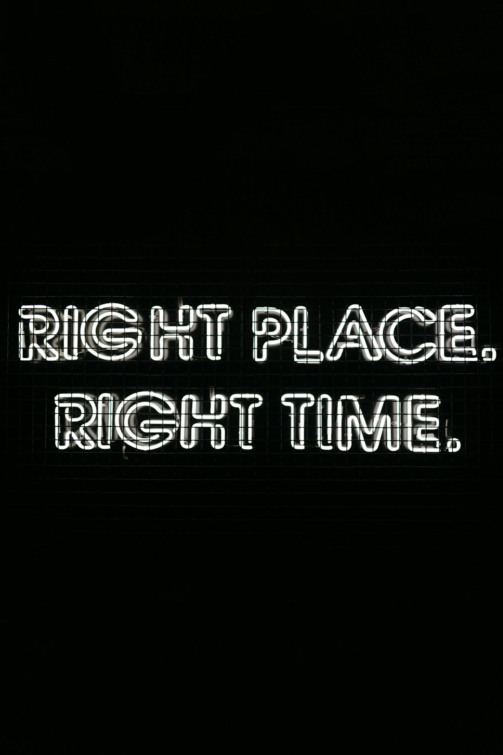 Glowing neon text on a black background saying 'Right Place. Right Time.' for motivation and inspiration.